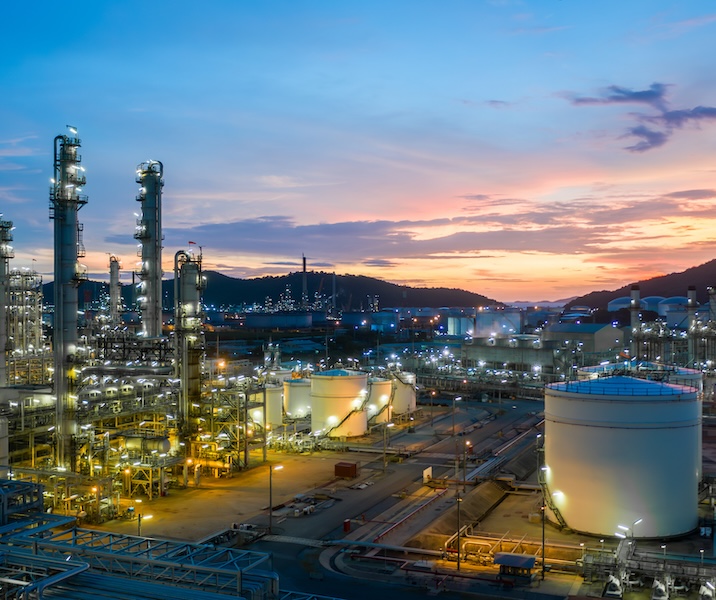 Aerial view oil and gas tank with oil refinery background at night, Glitter lighting of petrochemical plant with night, Manufacturing of petroleum, Products tank in petrochemical plant.