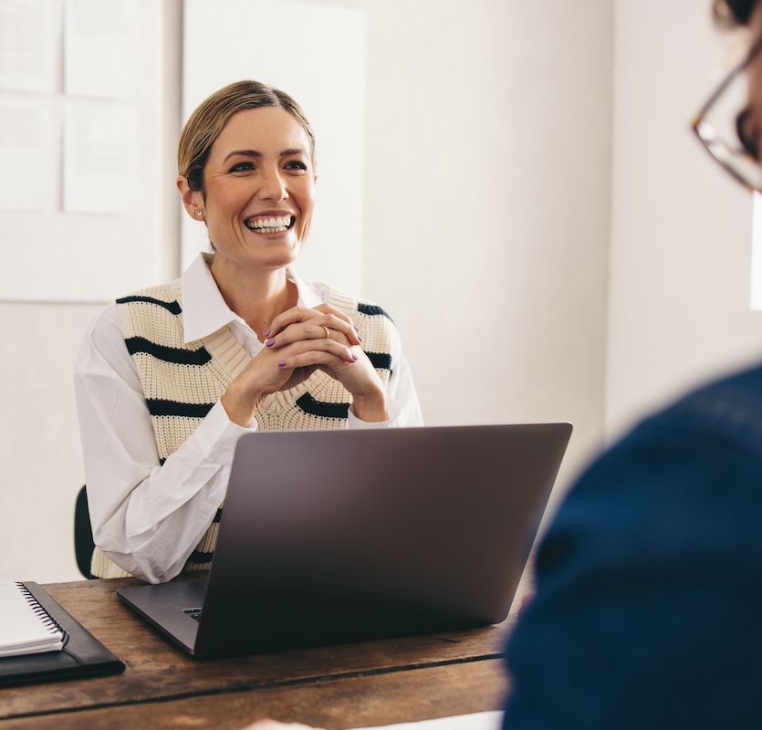 Happy hiring manager interviewing a job candidate in her office